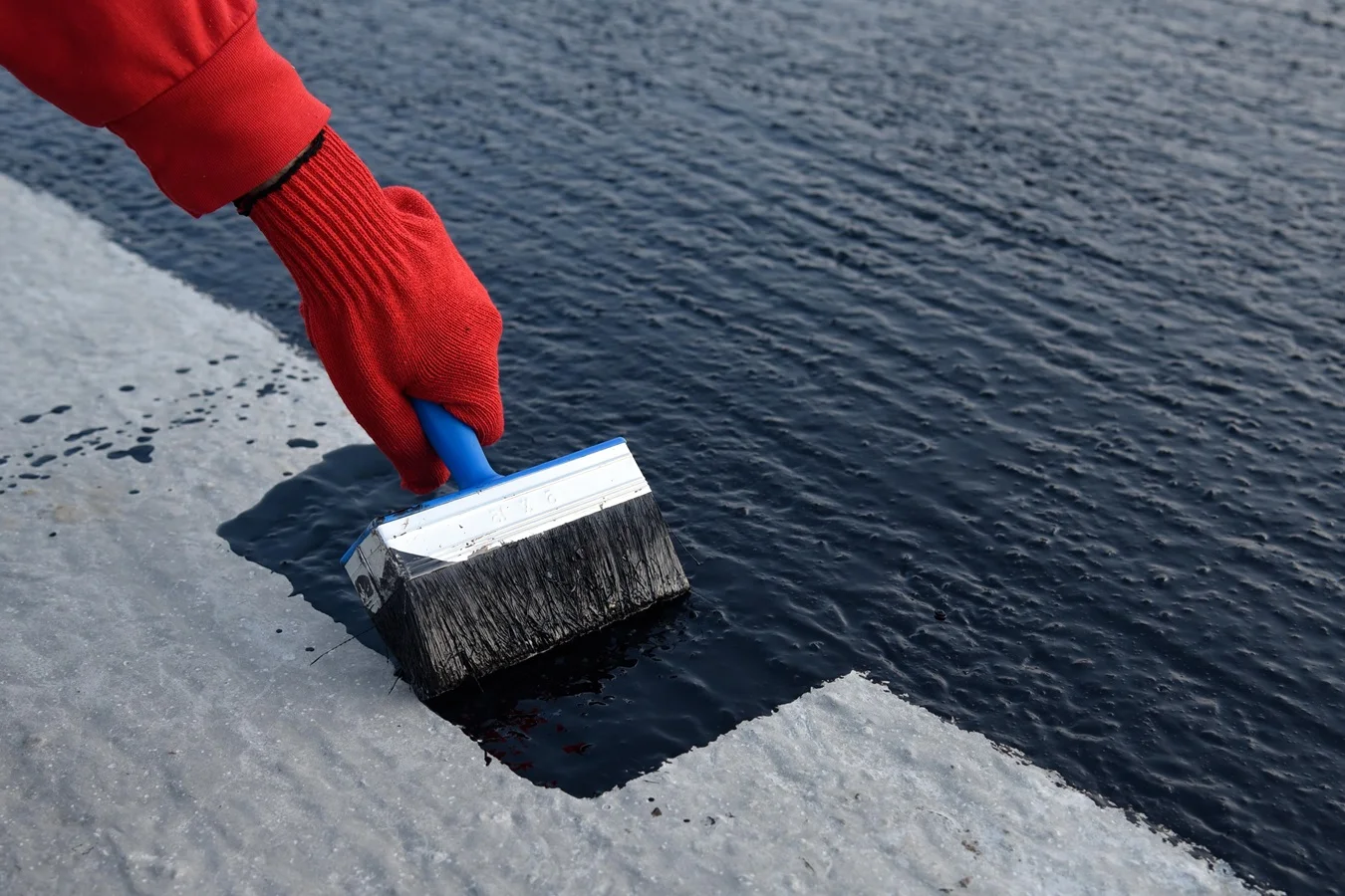 worker-applies-bitumen-mastic-on-foundation